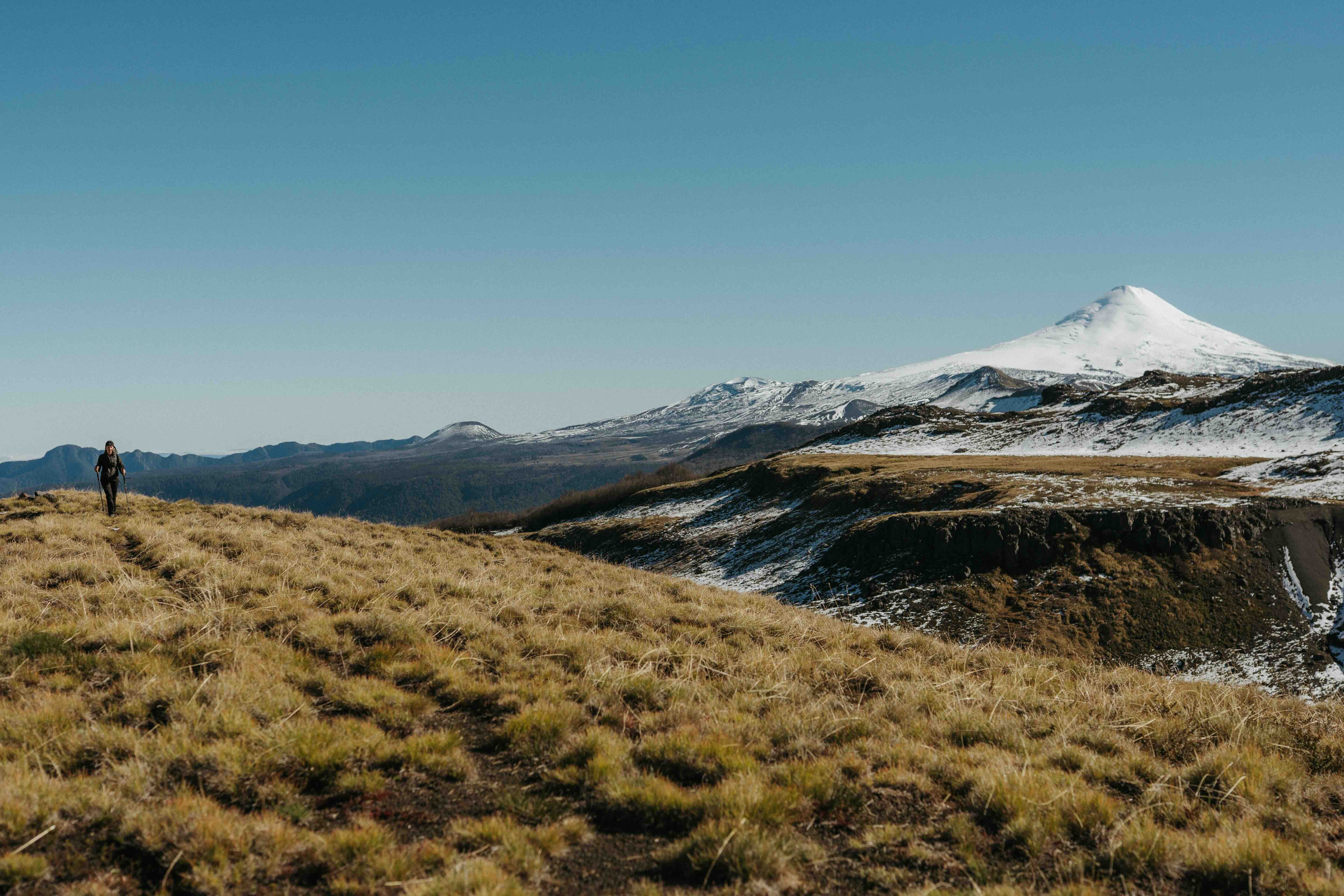 Senderista en la ruta Villarrica Traverse frente al volcán nevado